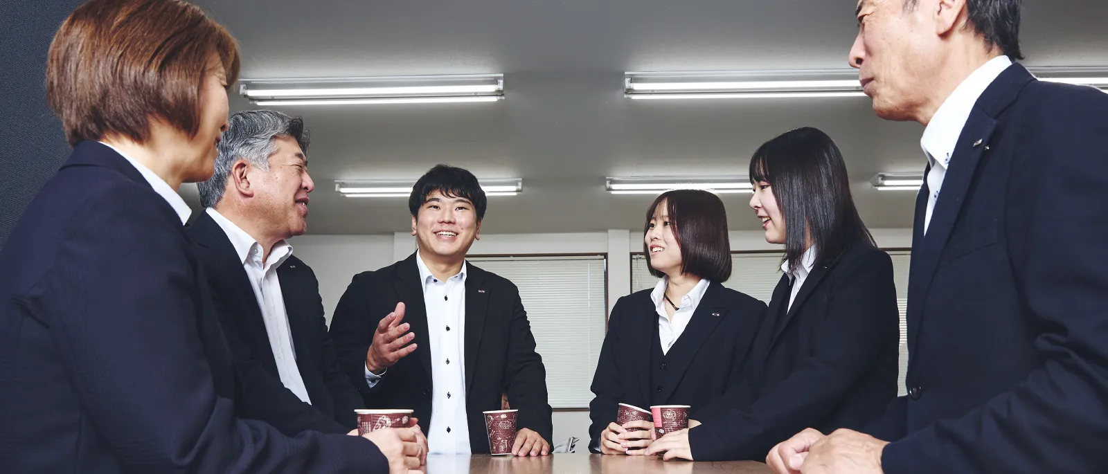 笑顔で会議を行う先輩社員